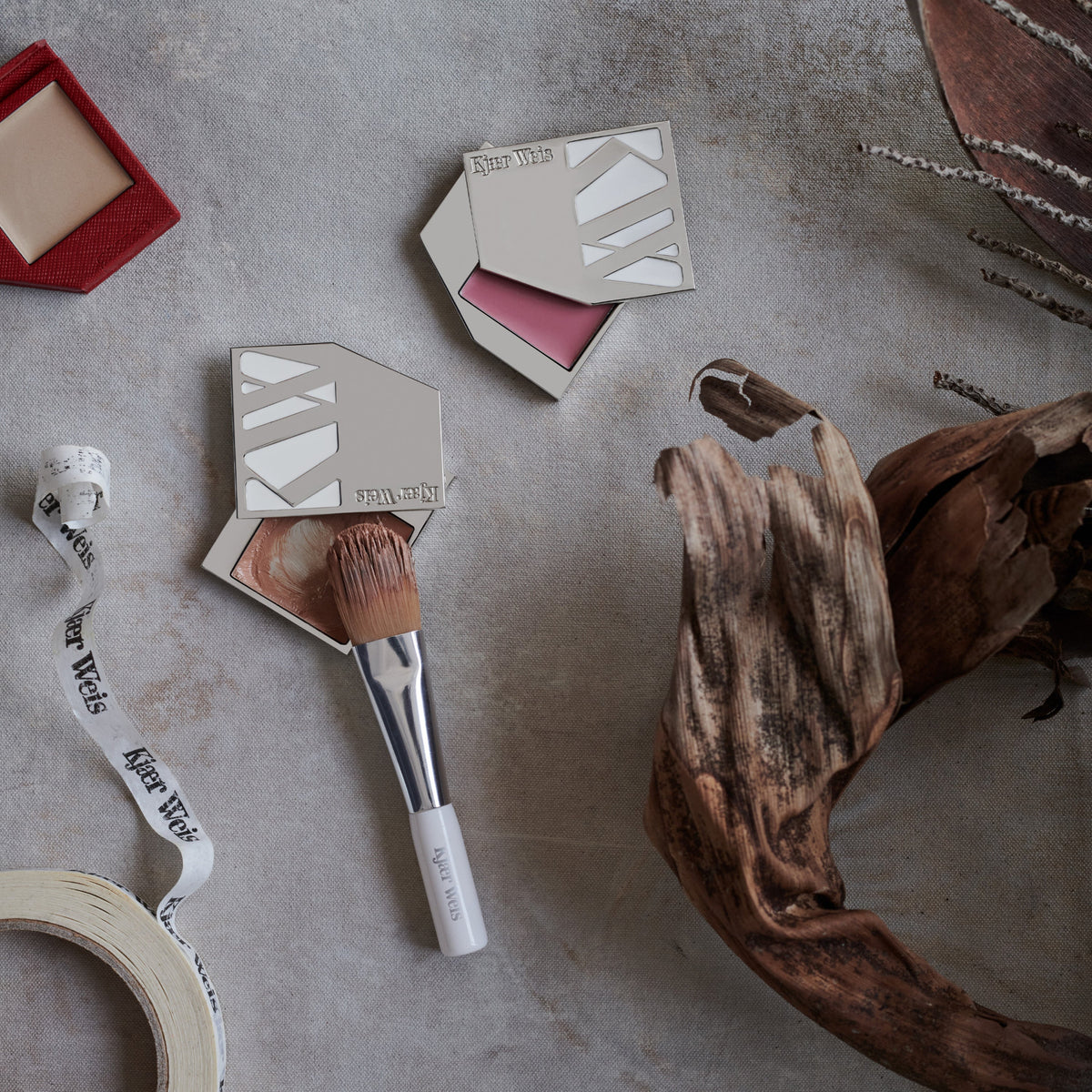 Kjaer Weis cream cheek makeup products, including Cream Blush and Cream Bronzer in Iconic Edition cases, Cream Glow in Red Edition compact, and the Blush-Foundation Brush.