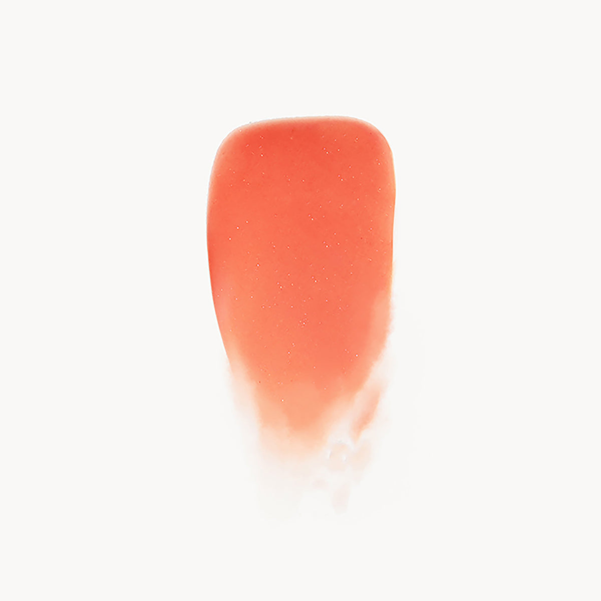Close-up of a coral-colored lip gloss swatch on a white background