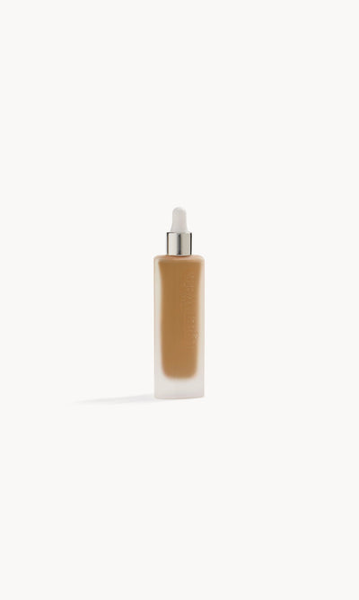 Frosted glass bottle with foundation inside and a white and silver pipette top
