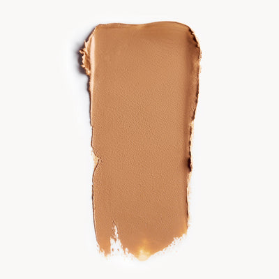 A wipe of medium, warm-toned cream foundation on a white background
