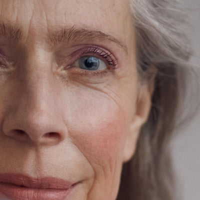 Close up of a person’s face wearing a pink blush