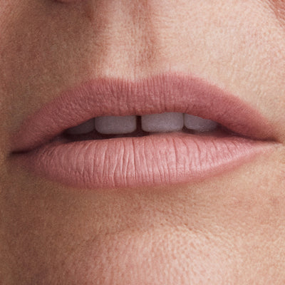 Close-up of a person's lips with a soft pink lipstick.