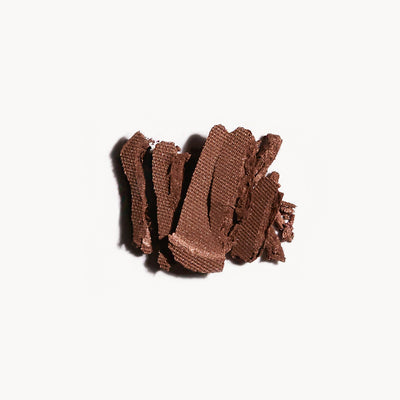 Crumbled up warm brown eye shadow on a white background